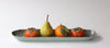 Fruits including a pear and persimmons on a checkered tray with a white background